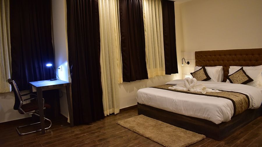 Kanchenjunga View Deluxe room - a modern room with clean and tidy queen size bed along with windows that overlook the mountains - Hotel Montana Vyoo