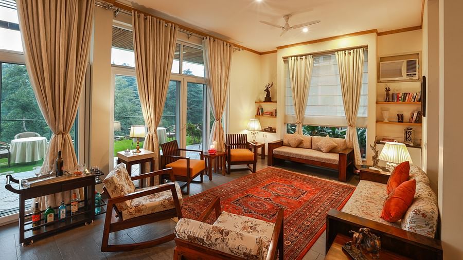 Aesthetically designed living room painted with pastel hues and features couches facing the outdoor landscapes2 - Lamrin Norwood Green Palampur