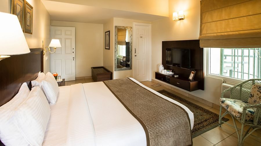 Closer view of deluxe room with tidy white linens and wardrobe on the side along with bedside lamps enhancing the beauty of the room - Lamrin Norwood Green, Palampur2