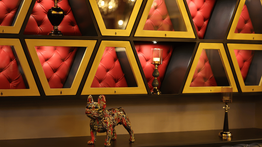 Wall at The Beatle Hotel, Powai, with red, tufted, triangular velvet recesses holding decorative objects.