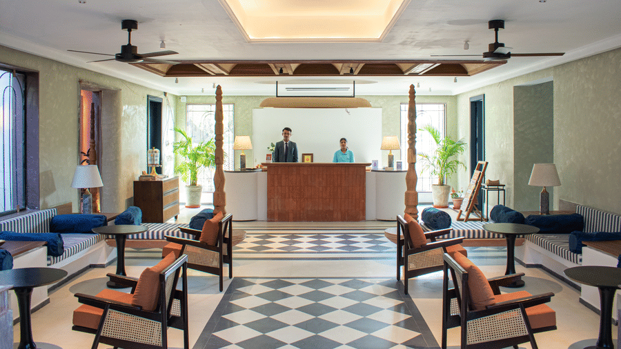 The hotel's reception area featuring a checkered floor, two receptionists, and a warm, welcoming ambiance.