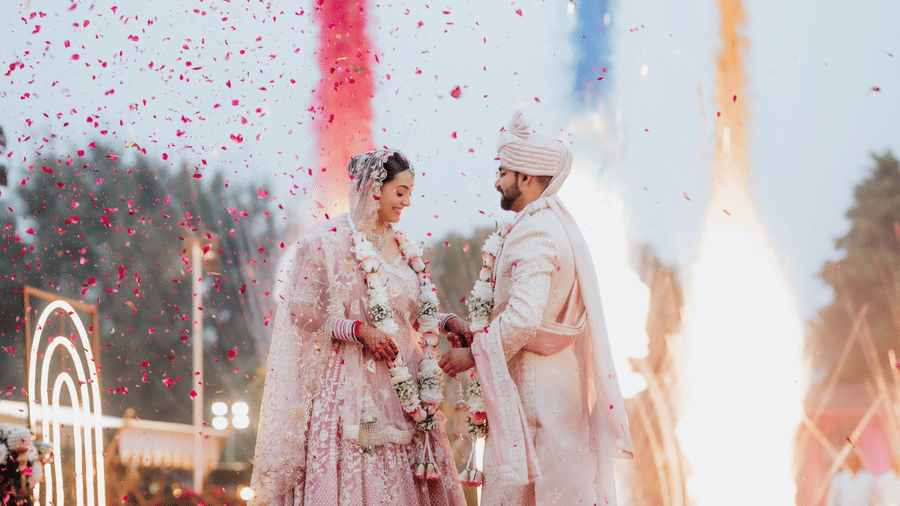 Couple performing wedding rituals with fireworks and vibrant colours at Umaid Palace