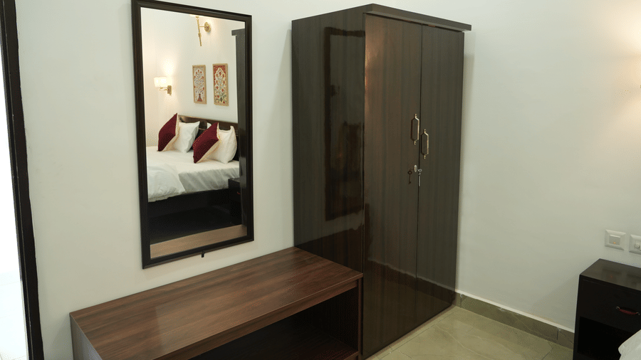 Guest room with a wooden dressing table, mirror, wardrobe and comfortable furnishings.