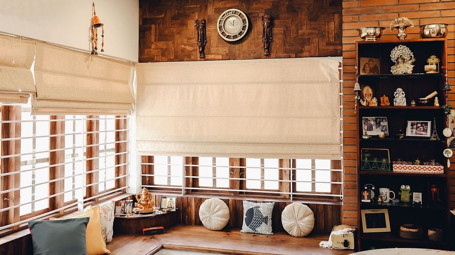 a large l-shaped sofa and a shelf with things kept in the Living Room at Ananda Holiday Home, Wayanad