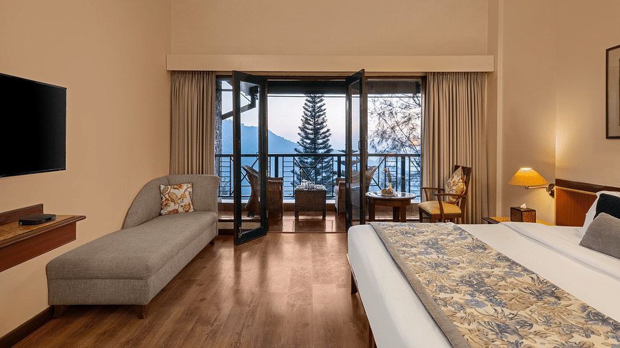 A side view of the Superior room with comfy comfy and beautiful view from window at Baikuth resort, kasauli.