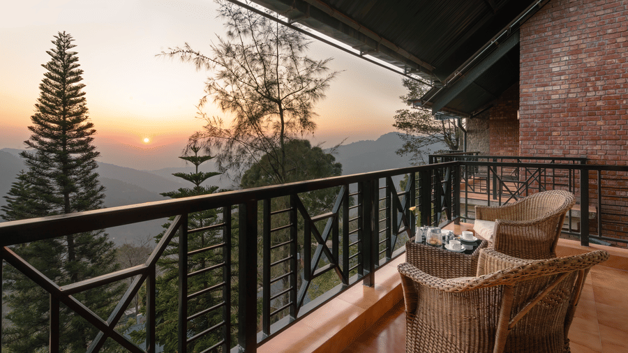 Superior Rooms seating area with a beautiful view of mountain during golden hour at Baikuth resort  kasauli.