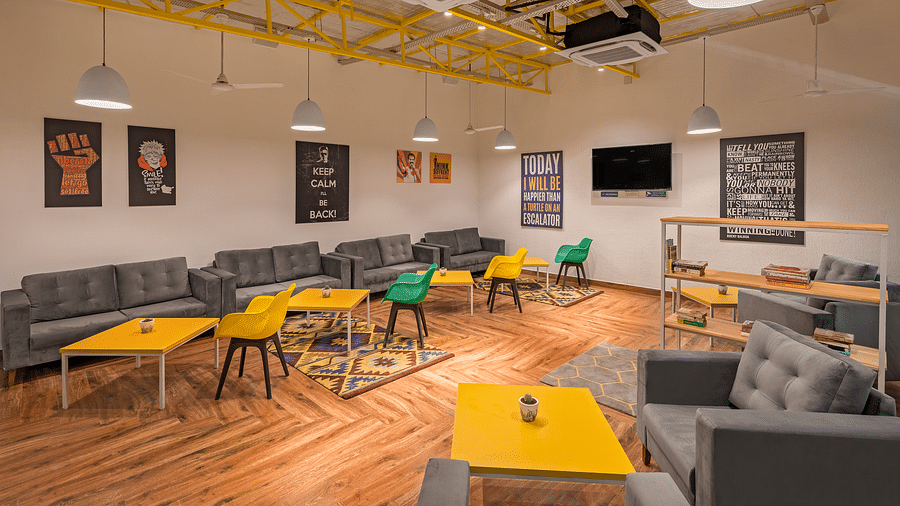 An image of interior of lounge area featuring sofas and bean bags for relaxation, coffee tables.