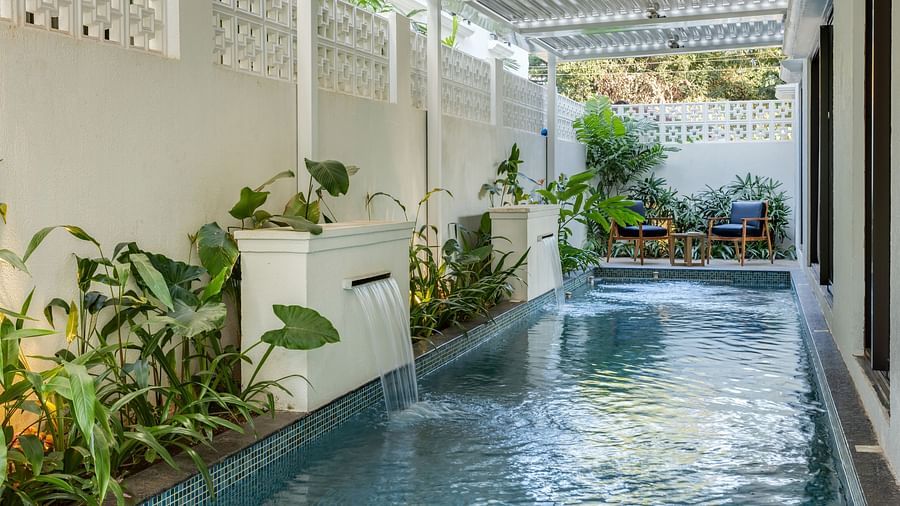 A tranquil swimming pool bordered by lush plants, with an overhead canopy providing a shaded oasis - BluSalzz Villas - Alocassia, Anjuna