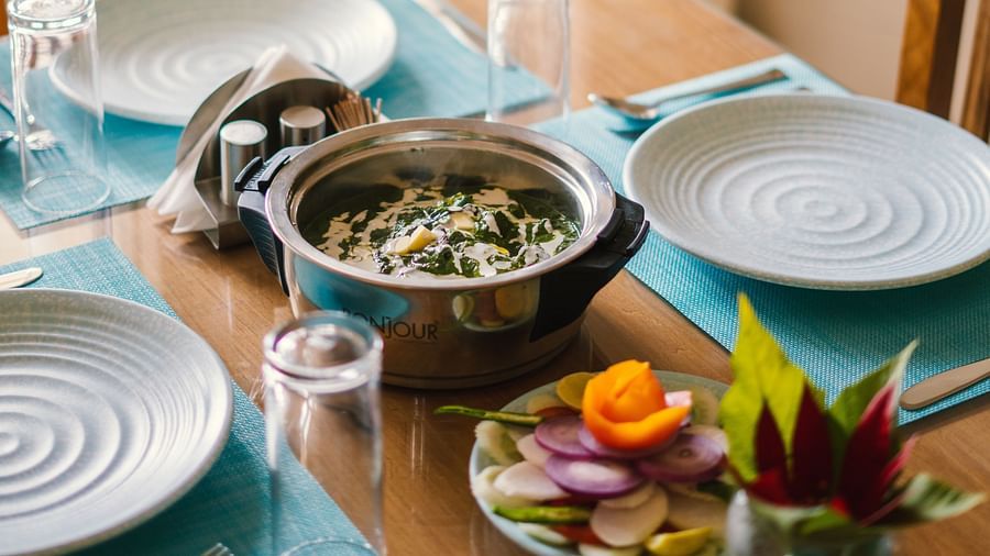 A close-up view of a table with a dish placed in the middle, and plates and glasses on the sides at BluSalzz Villas - The Green Roof, Bhimtal.