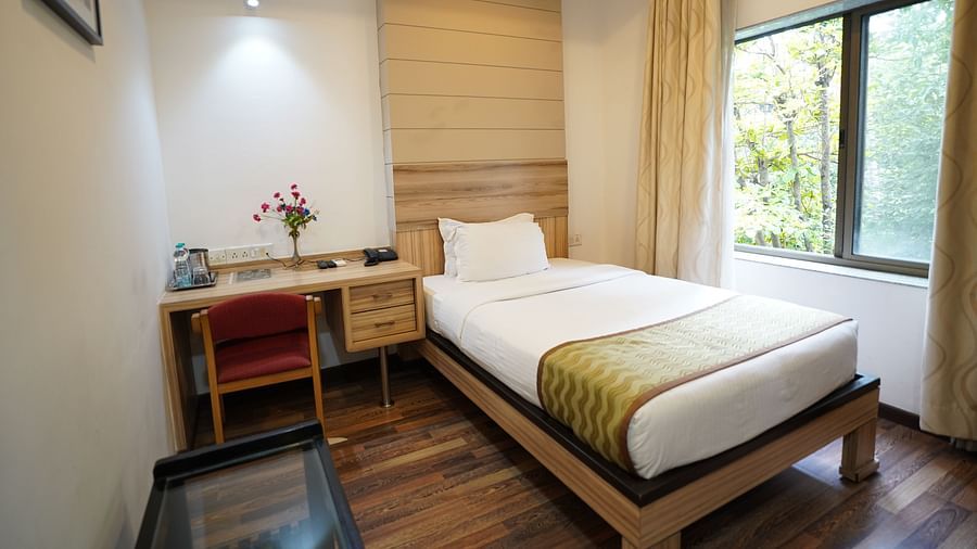 an image of a standard room with a working table and a chair at  City Centre Residency, Bangalore