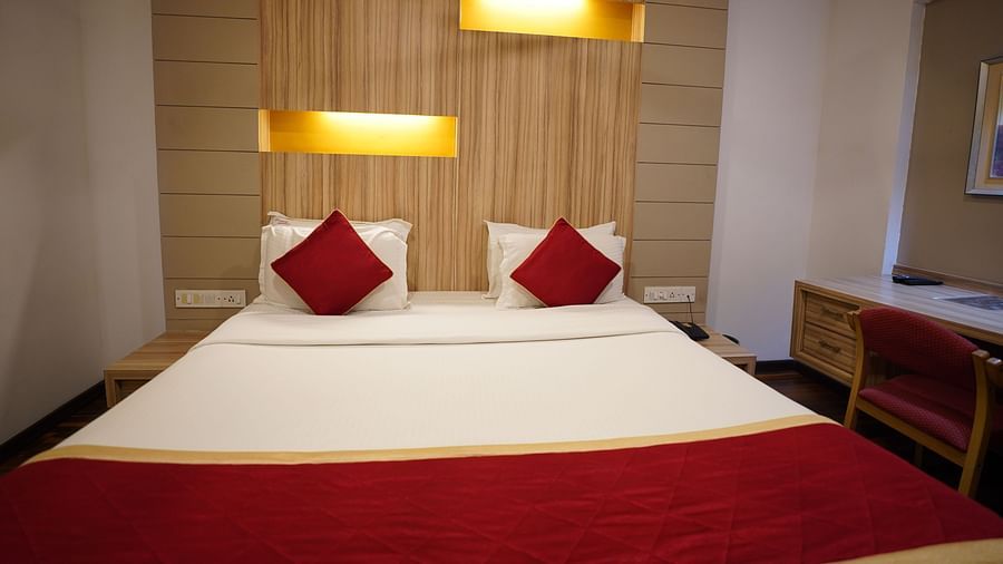 an image of a deluxe bedroom with a study table and a chair at  City Centre Residency, Bangalore