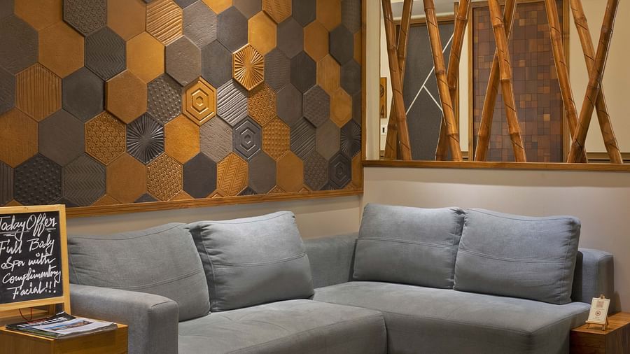 Image of the lounge area at Coral Reef Hotel and Spa in Port Blair featuring an L shape sofa against the wall with geometric pattern
