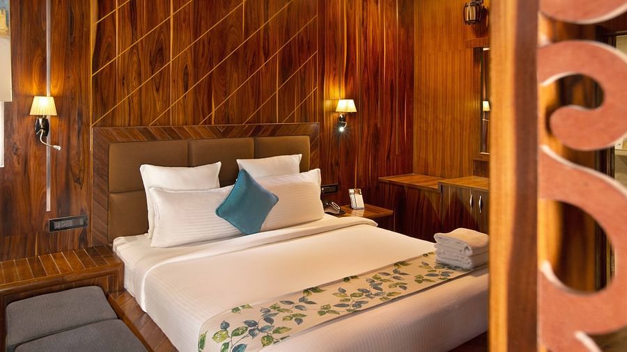 Image of a double bed with pillows and a cushion and a couple of lamps on bot sides at Image of the facade of Coral Azure at Coral Reef Resort and Spa in Havelock