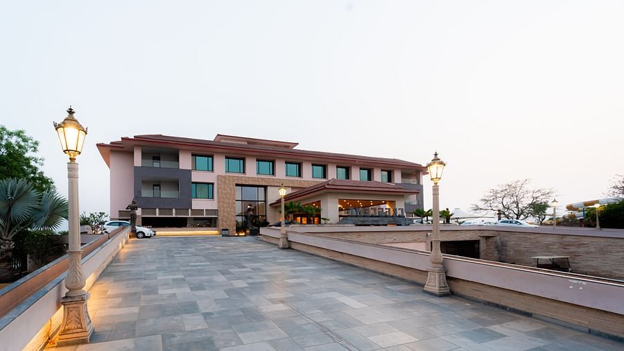 Facade view of Crescent Spa & Resort, Indore, set against a backdrop of a cloudy sky, showcasing its grand architecture