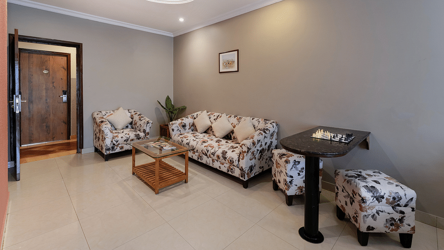 A spacious seating area in our Suite with a patterned sofa set - Cross Roads Inn, Bengaluru