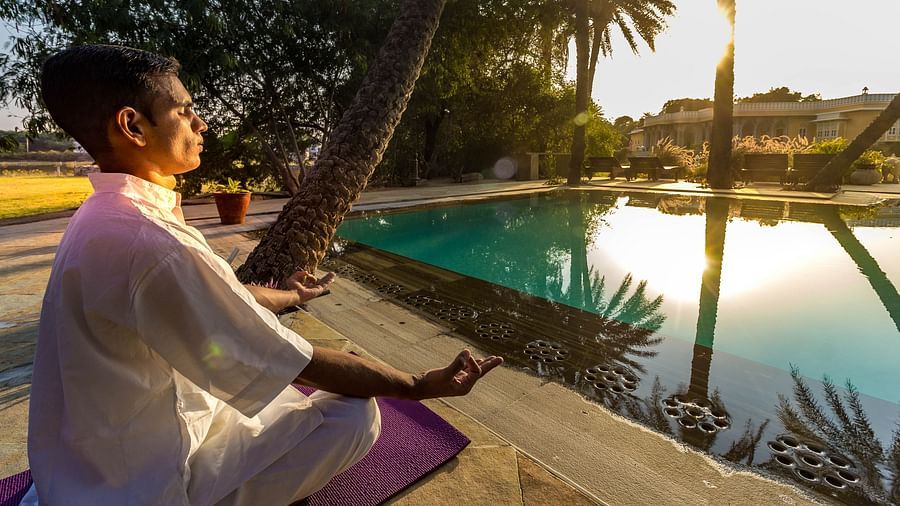 A person meditating as the sun rays fall on him - Dev Shree, Deogarh