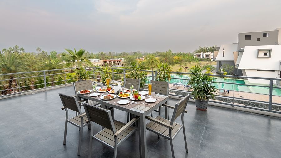A terrace at DLS Forest Vines Resort with a table for six, beautifully set with an array of dishes.