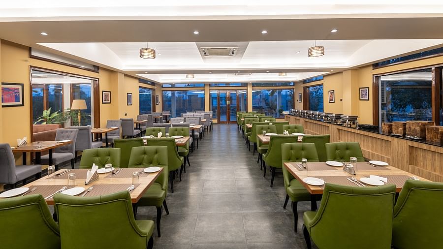 View from one end of the dining area at DLS Forest Vines Resort, with tables and chairs neatly set on both sides.