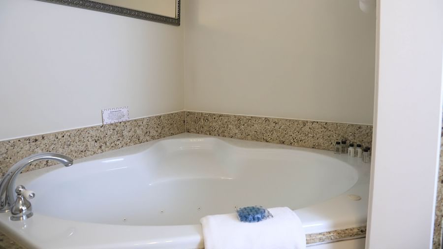 Corner whirlpool bathtub in a private bathroom at Hartstone Inn