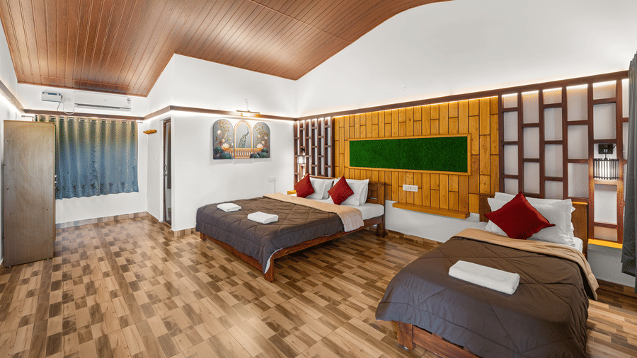 Family Room With Garden View 3 at Hatti Eden Coorg showcasing spacious interiors, a king size bed, a single bed, wooden décor, and a garden-facing entrance.