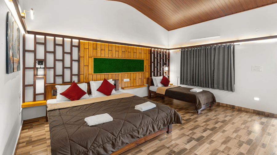 Spacious Family Room With Garden View 3 at Hatti Eden Coorg featuring one king size bed, one single bed, wooden accent wall, and contemporary interiors.