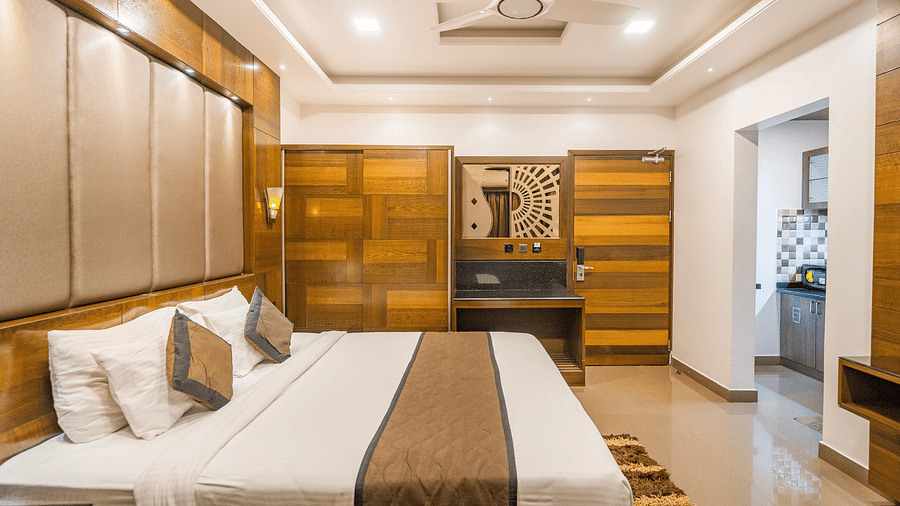 Side view of a room with a bed and a ceiling fan above the bed at Hotel Altitude, Madikeri.