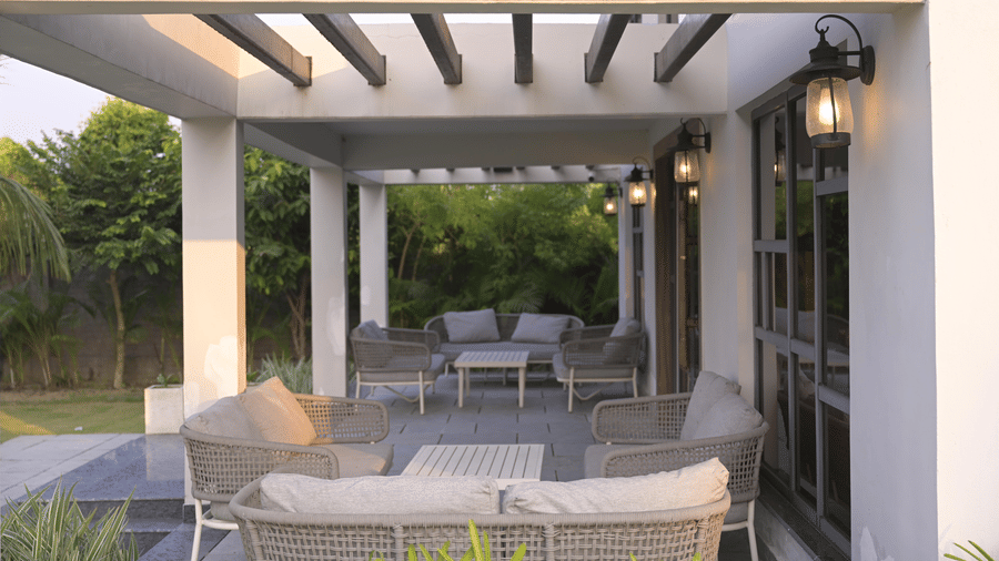 Outdoor seating under a pergola facing lush garden views at Hotel Sonar Bangla Mayapur.