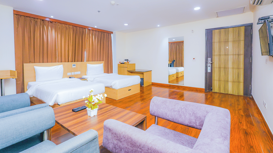 A spacious hotel suite living room with comfortable sofas and light coloured decor - Hyphen Business Hotel, Noida