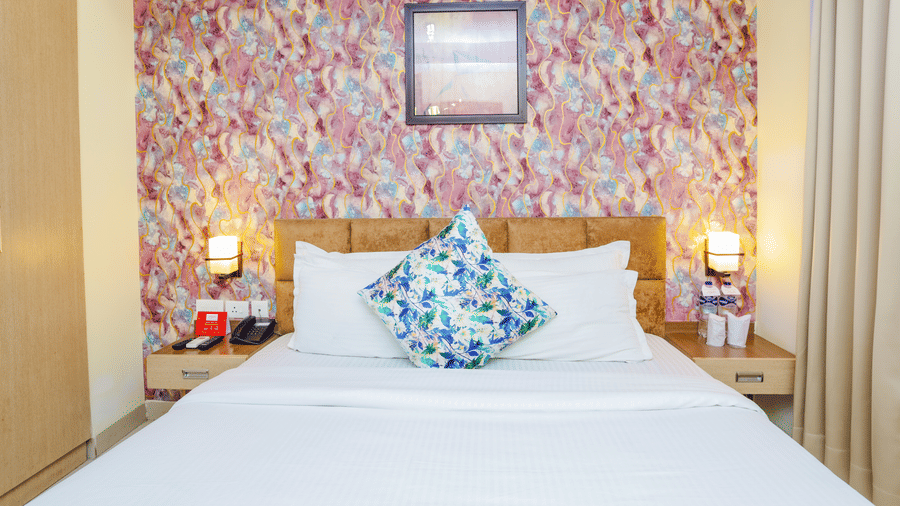 A comfortable hotel room with a bed and floral patterned wallpaper - Hyphen Grand, Haridwar