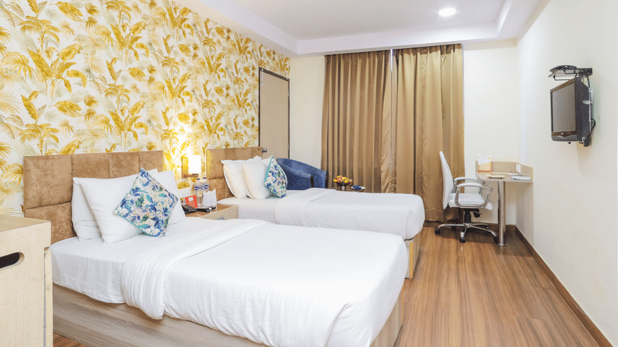 A spacious hotel room with a double bed, wooden flooring, and a large window - Hyphen Grand, Haridwar