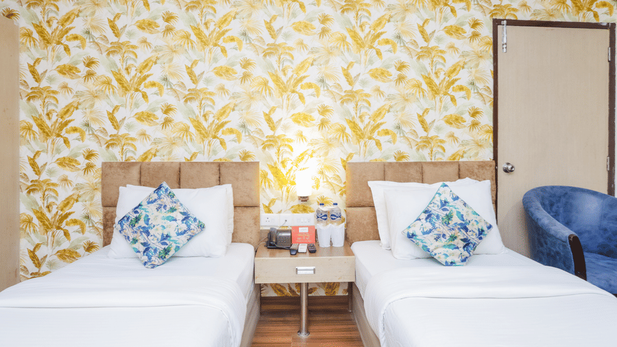 A hotel room with two single beds, a floral patterned headboard, and a bedside lamp - Hyphen Grand, Haridwar