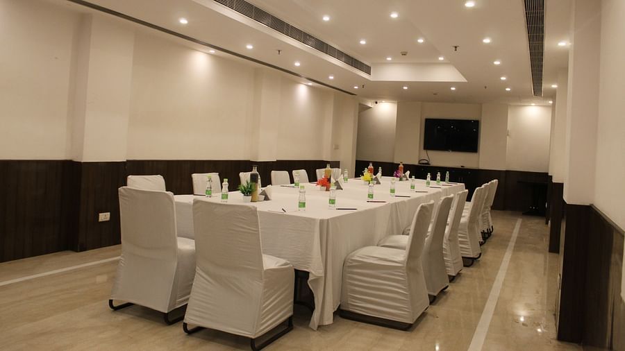 An image of a conference hall featuring a a large table at the centre surrounded by several chairs at Inde Hotels Vista Woods