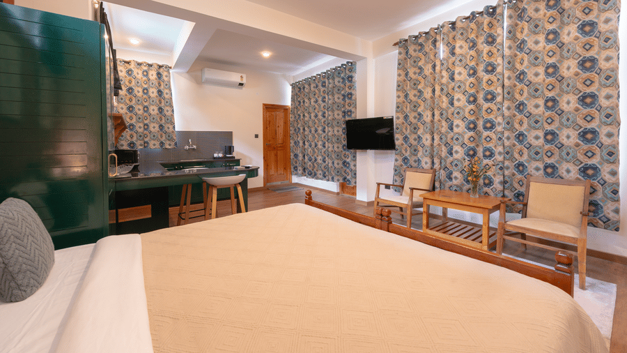 Perspective from the bed looking out toward the seating area and large windows with patterned drapes - Johnson Lodge & Spa, Manali