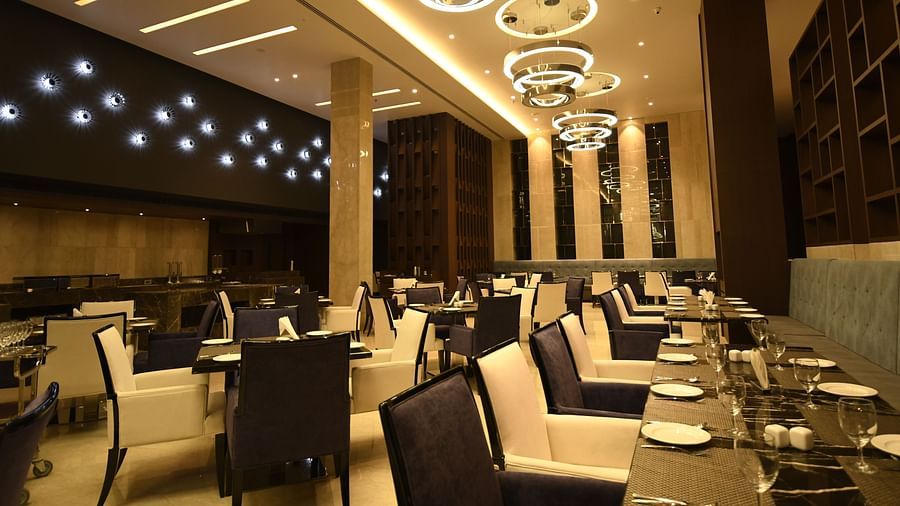  A dining area with cosy lighting, featuring tables set and chairs arranged for guests to savour their meal