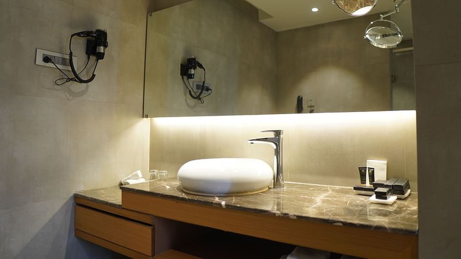 Spacious bathroom with a large rectangular mirror and warm lighting