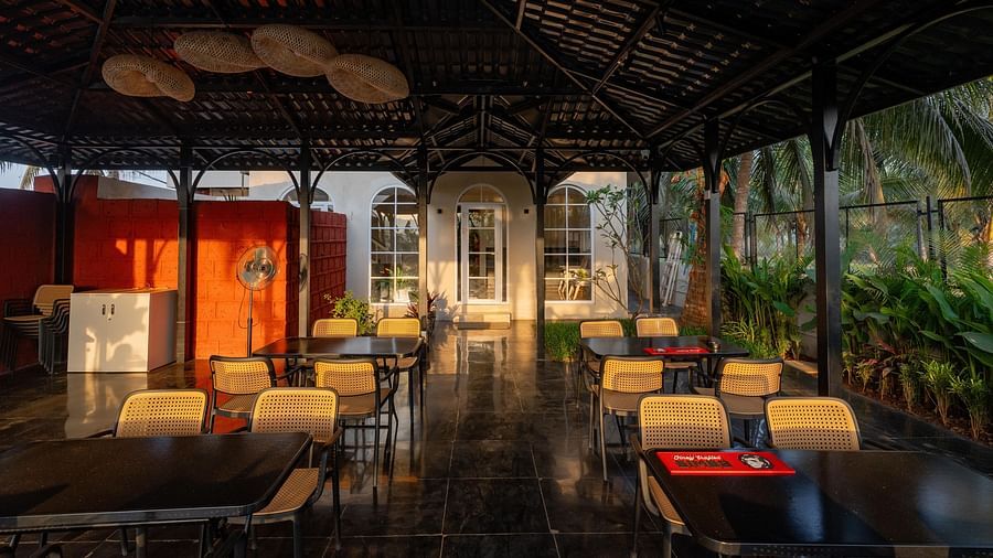 A partially enclosed outdoor dining area with a dark, peaked roof at Kssemya.