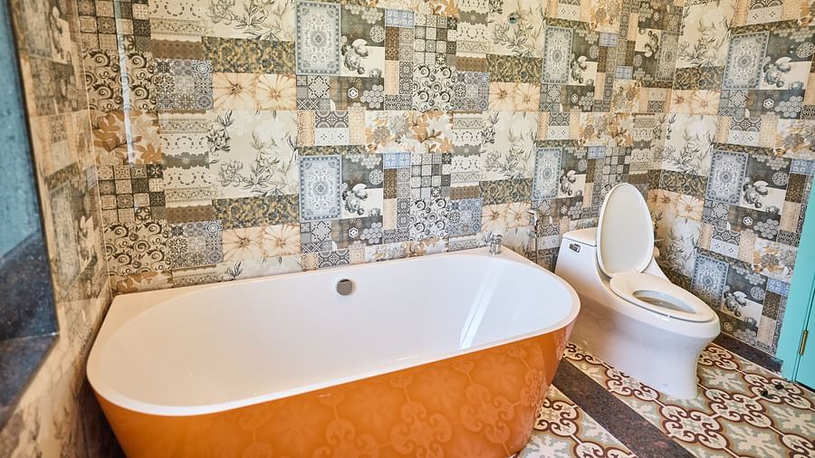 A bathtub with a western toilet to the side at Mayfair Manor, Alibag