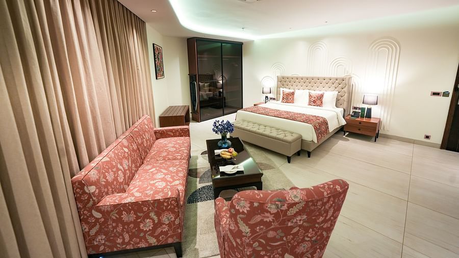 An image of Namami Suite in Bankhandi with a large queen size bed, upholstered furniture and a teapoy table - NAMAMI BY ZENQ BANKHANDI