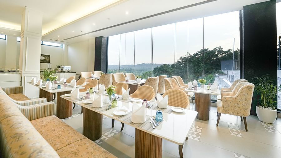 An image showcasing our cosy restaurant with dining arrangements that offer views of the mountains through the large windows - NAMAMI BY ZENQ BANKHANDI