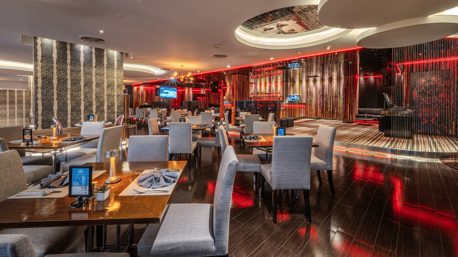 Contemporary seating, glossy black flooring, warm ambient lighting, and a stylish all-day dining atmosphere at Flava Restaurant, offering some of the best food in Sukhumvit.