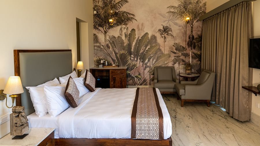 A spacious room with nature-themed wallpaper and elegant decor - Rajbagh Wellness, Udaipur.