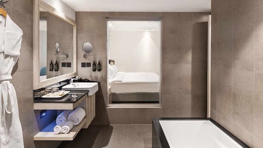 Contemporary bathroom featuring a bathtub, rain shower and vanity area.