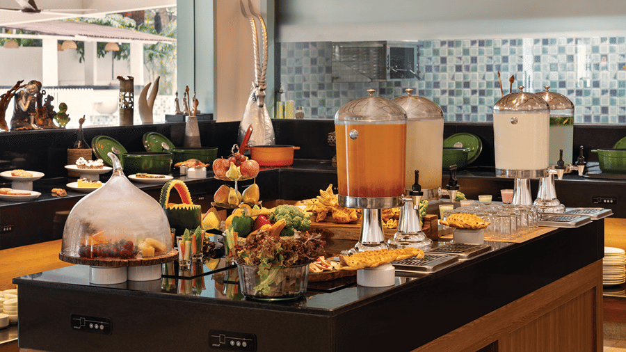 Buffet spread with fresh dishes and beverages arranged on a dining counter.