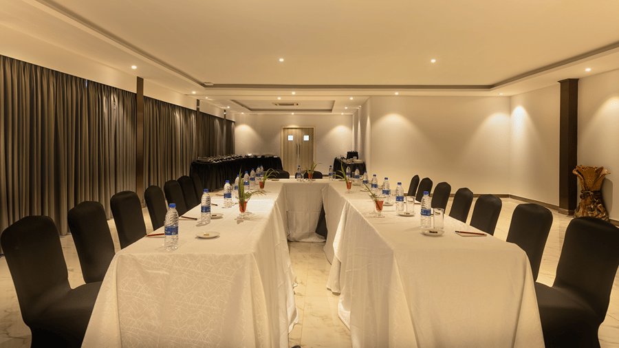 Indoor event space arranged with banquet tables and chairs.
