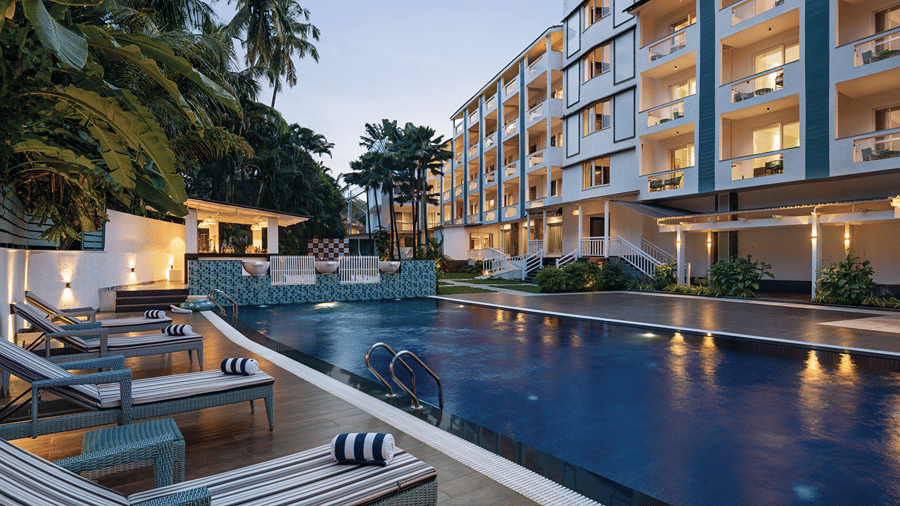 Outdoor swimming pool with loungers overlooking the hotel grounds.