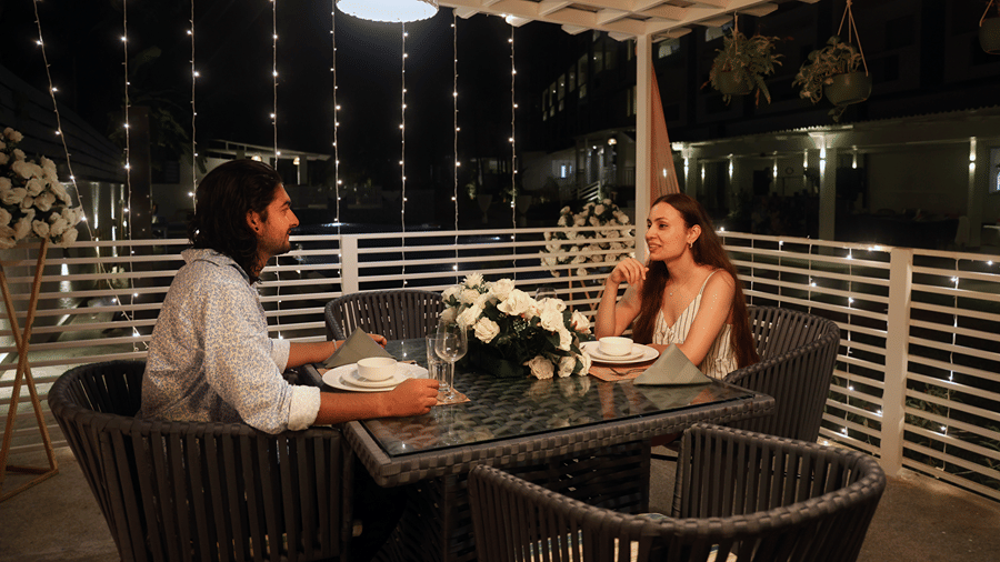 Guests enjoying an evening meal on an outdoor terrace.