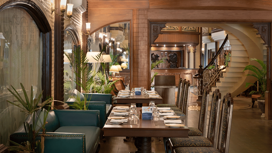 Dining tables and chairs, inside a wood-accented restaurant room at Ramada by Wyndham Mussoorie Mall Road.