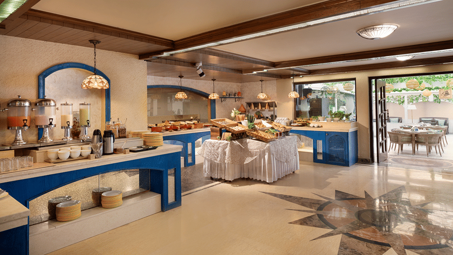 A buffet spread featuring serving tables and blue counters is set up inside a restaurant at Ramada by Wyndham Mussoorie Mall Road.