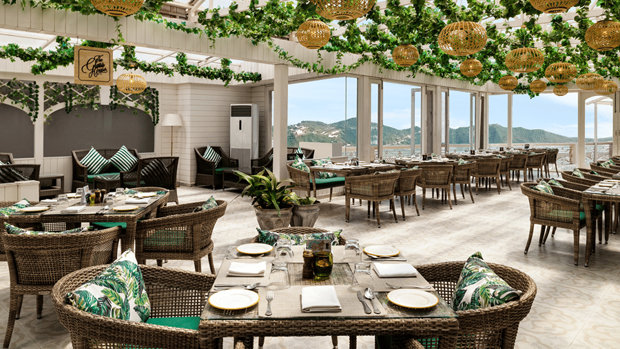 A dining terrace featuring tables, chairs, and hanging green foliage decorations at Ramada by Wyndham Mussoorie Mall Road.