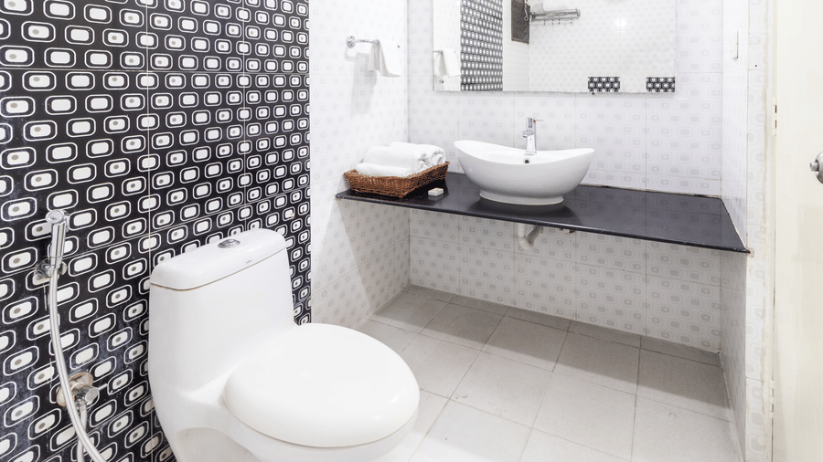 Modern bathroom with monochrome patterned tiles and vanity at Sanctum Suites Domlur Bangalore